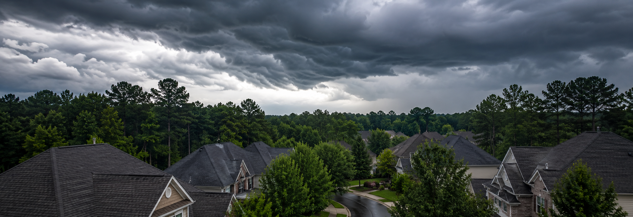 Dramatic storm clouds building over a Peachtree City neighborhood with rooftops visible below