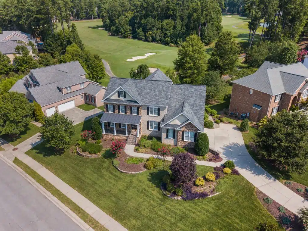 A picture of a 2 story house with a large portion of garden. Peachtree City GA Roofer - Home Page Banner