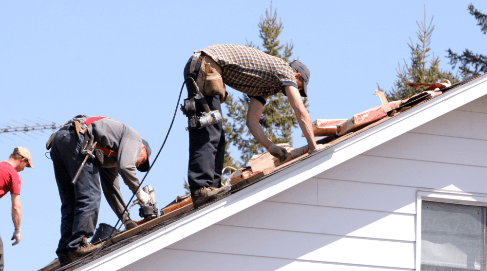 Roofers repairing a residential roof for Sure Thing Roofing Contractor.