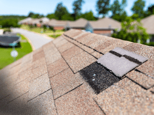 Damaged roof shingle with wear near a vent on a roof in Georgia.